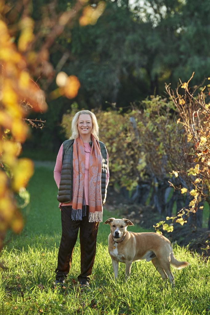 Photo of Vanya Cullen and her dog in the vineyard