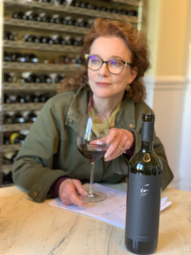 woman drinking a glass of alma negra m blend wine from Argentina